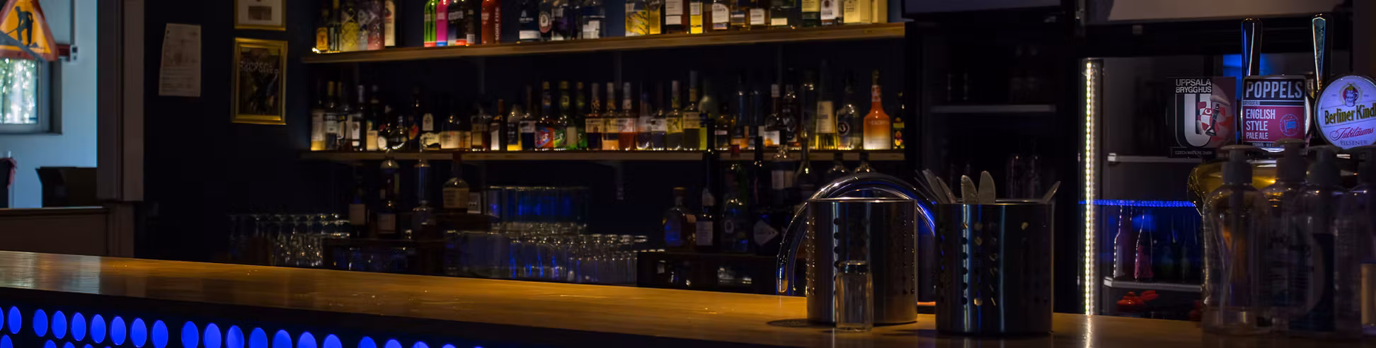 Baren i Kistan 2.0 med många flaskor och kylar i bakgrunden.